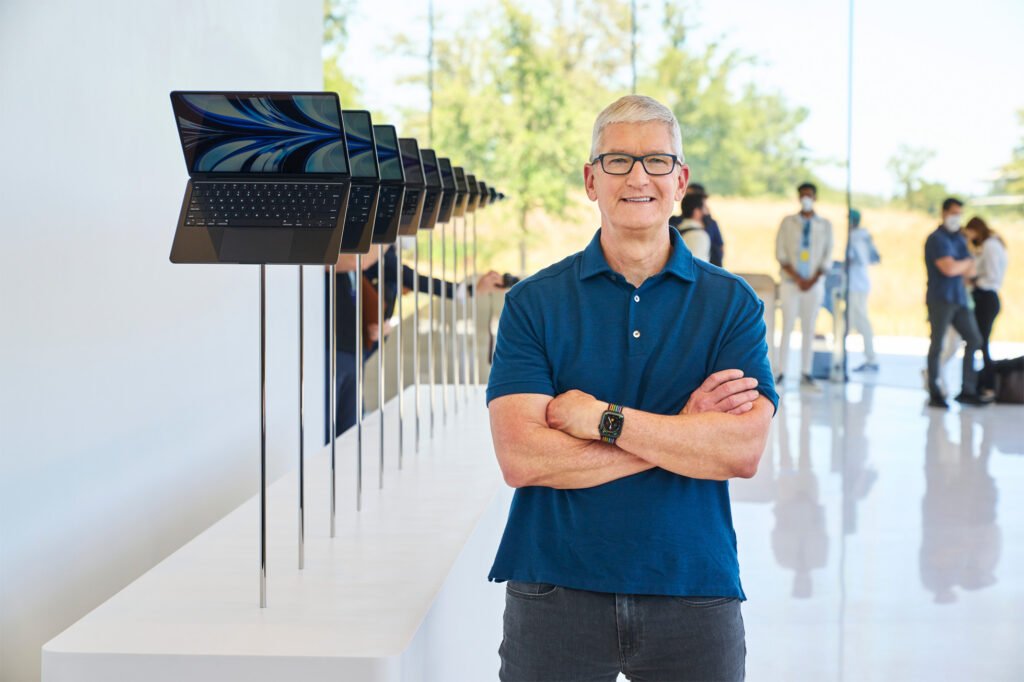 Apple CEO Tim Cook steht vor einer Galerie mit MacBook Air auf der WWDC 2022.